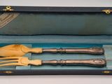 two forks and spoons in a box on a table