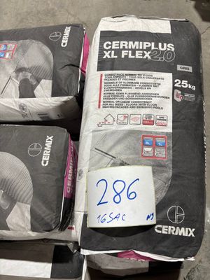 trois sacs de ciment posés par terre les uns à côté des autres