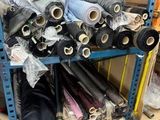 many rolls of fabric on a rack in a warehouse