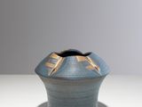 un petit vase bleu orné d'un motif doré
