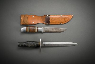 three different types of knives on a table with a leather sheath