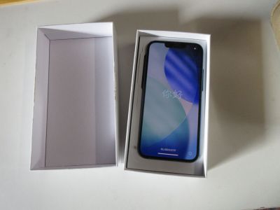 une image représentant une boîte contenant un téléphone, posée sur une table