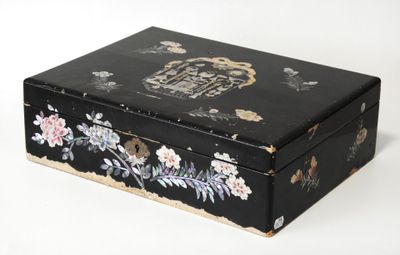 une petite boîte noire ornée d'un motif floral