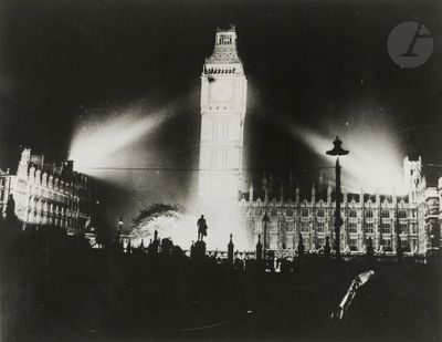 black and white photograph of a large clock tower lit up at night