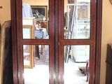 a tall wooden cabinet with two mirrors on the doors