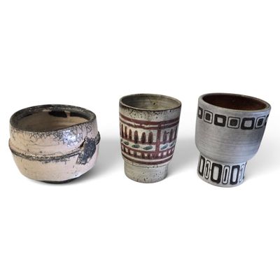 trois tasses posées côte à côte sur une surface blanche