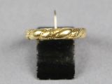 gros plan d'une bague en or sur une surface noire