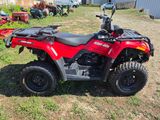 an image of a red four wheeler atv parked in the grass
