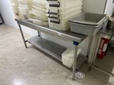 a metal table with a bunch of plastic containers on top of it