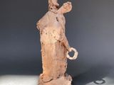 a sculpture of a woman holding a bird on a table