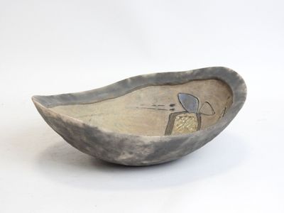 a small bowl with a bird on it on a white surface
