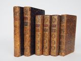 plusieurs vieux livres sont alignés sur une surface blanche