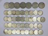 a close up of a pile of silver coins on a white surface