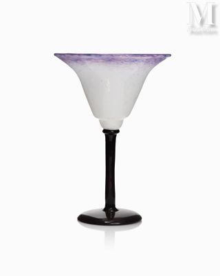 un vase en verre violet et blanc posé sur un socle noir