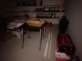 une photo d'une chambre en désordre avec un bureau et une valise