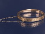 une image représentant un bracelet en or entouré d'une chaîne
