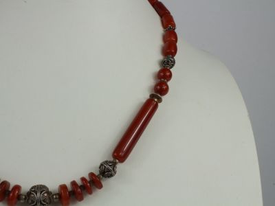 an image of a necklace with red beads on a mannequin mannequin
