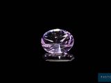 a purple diamond on a black surface with a black background