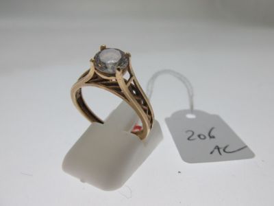 une bague en or sertie d'un diamant, à côté d'une étiquette de prix