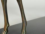 a close up of a bronze statue of a woman ' s legs