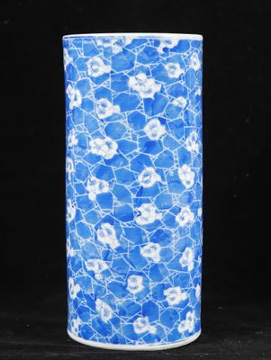 blue and white vase with flowers on it against a black background