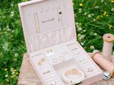 a small pink box with jewelry on a wooden table