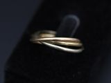 a close up of a gold wedding ring on a black surface
