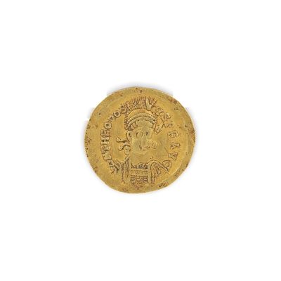 gros plan d'une pièce d'or sur une surface blanche