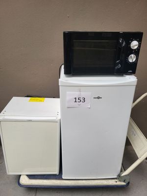 a microwave sitting on top of a cart next to a refrigerator