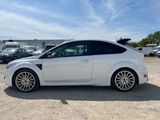the white ford focus is parked in a lot with other cars