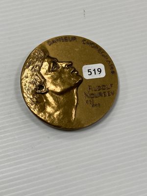 a close up of a gold coin with a dog on it