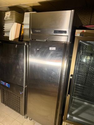 stainless steel refrigerators and freezers in a kitchen with tile flooring