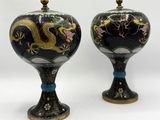 une paire de vases noirs et dorés ornés de motifs de dragons