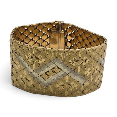 gros plan d'un bracelet en or sur fond blanc