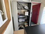 un plan de travail noir dans une pièce dont la porte est rouge