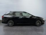a black car is parked in a room with a white wall