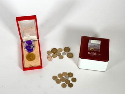 une petite boîte sur laquelle se trouvent des pièces et une médaille