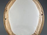 a round mirror that is made of paper and has holes in it