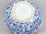 blue and white porcelain bowl with a design of flowers and trees