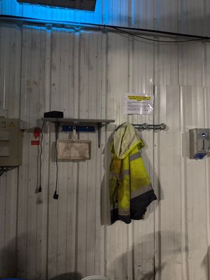 un homme debout dans une pièce baignée d'une lumière bleue