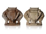 two statues of elephants holding a shield and a shield with a shield on it
