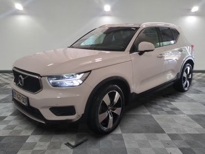 Le SUV Volvo blanc est garé dans une pièce dont le sol est en damier.
