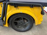 a yellow golf cart with a black seat on it