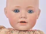 a baby doll that is wearing a dress with flowers on it