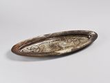 a silver plate with a design on it on a white surface