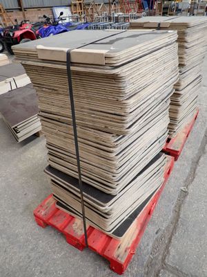 Plusieurs piles de bois sont posées sur une palette dans un entrepôt