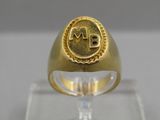 a close up of a gold ring with a monogram on it