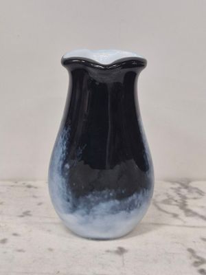 un vase noir et blanc posé sur une table en marbre