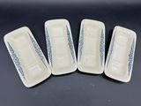 quatre assiettes blanches ornées de motifs bleus, posées sur une table