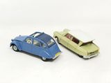 two toy cars sitting next to each other on a white surface